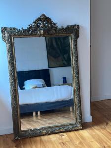 einem Spiegel, der ein Bett in einem Zimmer reflektiert in der Unterkunft Wanatan Chambre d'hôtes in Penmarcʼh