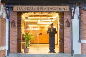 mężczyzna stojący w drzwiach restauracji w obiekcie Darbar Heritage Inn w Katmandu
