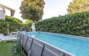 ein Pool in einem Garten neben einer Hecke in der Unterkunft Gorgeous Home In Viareggio With Kitchen in Viareggio