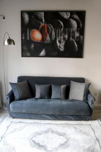 eine blaue Couch in einem Wohnzimmer mit einem Bild an der Wand in der Unterkunft issi in Tbilisi City