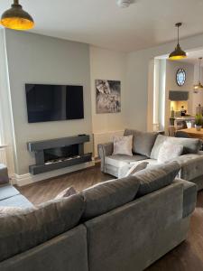 a living room with a couch and a flat screen tv at Castle View House in Clitheroe