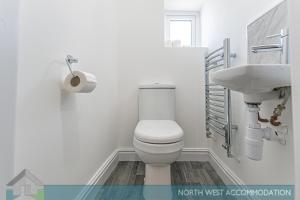 a bathroom with a toilet and a sink at Wellfield Serviced Accommodation (Warrington) in Warrington