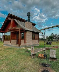 a log cabin with a swing in front of it at Cabanas Vale Verde in Praia Grande