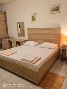 a bedroom with a large bed with a wooden headboard at Lovely Bosnian Home in Mostar