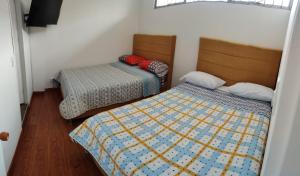 a room with two beds in a room at Estadía El Dorado in Bogotá