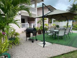 patio ze sprzętem do grillowania, stołem i krzesłami w obiekcie Mokara Holiday Apartment w Mahé