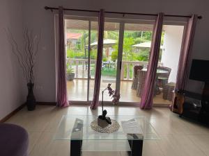 sala de estar con mesa de cristal frente a una ventana en Mokara Holiday Apartment, en Mahe