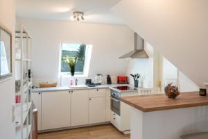 una cocina con armarios blancos y una ventana en Apartment 1 - Privatstall am Berghof, en Einbeck