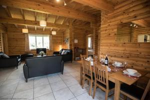 uma sala de jantar e sala de estar num chalé de madeira em Quail Lodge - Nordic Log Cabin em Selby