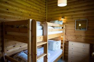 a bedroom with two bunk beds in a log cabin at Quail Lodge - Nordic Log Cabin in Selby