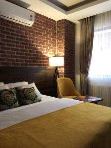 um quarto de hotel com uma cama e uma parede de tijolos em GRAND DELUX HOTEL em Samsun