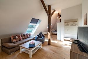 a living room with a couch and a tv at Apartment 1 - Privatstall am Berghof in Einbeck