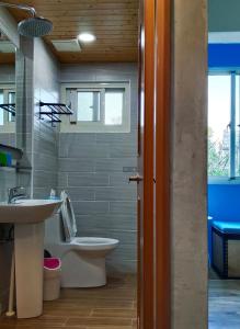 La salle de bains est pourvue de toilettes blanches et d'un lavabo. dans l'établissement 東海小時光 Tong Hai Time Homestay, à Longjing