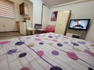 sypialnia z łóżkiem z fioletowymi kwiatami w obiekcie Apartman u centru Prnjavor w mieście Prnjavor