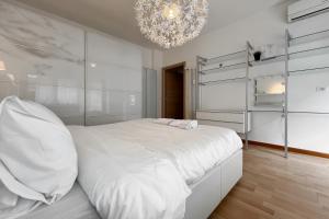 um quarto branco com uma cama grande e um lustre em La Casa di Roma em Roma