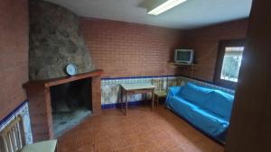 a living room with a blue couch and a fireplace at Casa turística Poncehouse in Tomelloso
