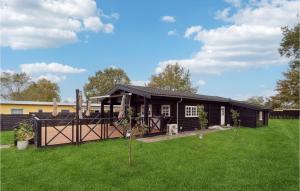 赫爾辛厄的住宿－Cozy Home In Helsinge With Kitchen，一座带院子和房子的黑色房子