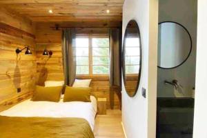 een slaapkamer met een bed, een spiegel en een wastafel bij Bianca appartement proche centre in Megève +8 foto's