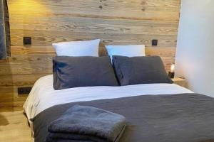 een groot bed met blauwe kussens in een slaapkamer bij Bianca appartement proche centre in Megève