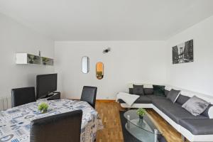 - un salon avec un canapé et une table dans l'établissement "Joie de vivre" - Parisian Spacious & Charming flat, à Asnières-sur-Seine