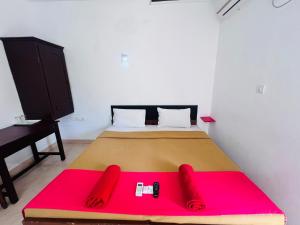 a bedroom with a large bed with a red blanket at Hotel Sunday - Townhouse Club Airport Trivandrum in Trivandrum