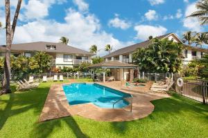 a backyard with a swimming pool and a house at Regency 321 in Koloa