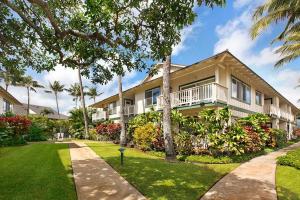 a large house with a porch and a yard at Regency 321 in Koloa