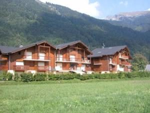 a large building in a field with a mountain at Appartement Samoëns, 4 pièces, 6 personnes - FR-1-629-133 in Samoëns