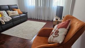- un salon avec un fauteuil en cuir et un canapé dans l'établissement Garden and Seaview Apartment - Free Parking, à Funchal