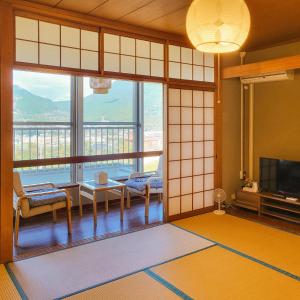 ein Wohnzimmer mit einem großen Fenster mit Aussicht in der Unterkunft Yufuin Monday 湯布院マンデー in Yufu