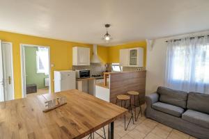 cocina y sala de estar con mesa y sofá en Gîte maison à Montendre, en Montendre