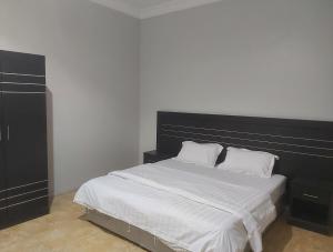 um quarto com uma cama grande e uma cabeceira preta em اجنحة ارمادا em Al Qunfudhah