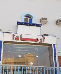 uma fachada de loja com um letreiro de néon. em اجنحة ارمادا em Al Qunfudhah