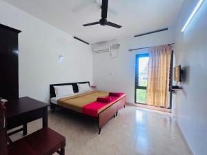 a bedroom with a bed and a window at Hotel Sunday - Townhouse Club Airport Trivandrum in Trivandrum
