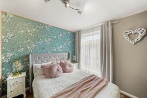 a bedroom with a bed with pink pillows on it at Modern 1 Bed Apartments Near Middlesex Uni in Hendon in Colindale