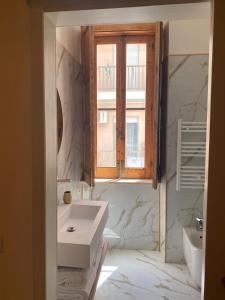 een badkamer met een wastafel en een raam bij Ca' Amaranta in Margherita di Savoia