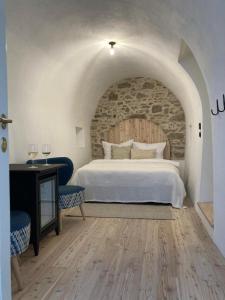 a bedroom with a white bed and a stone wall at Am Znaimertor in Retz