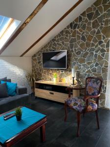 a living room with a tv on a stone wall at Apartment No10 in Golubac