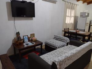 a living room with a couch and a tv on the wall at A&M Alojamiento - Lluvia de Oro 2554 in Puerto Rico