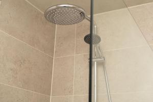 een douche met een douchekop in de badkamer bij Let’s Go in Oostende