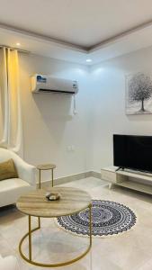 ein Wohnzimmer mit einem Couchtisch und einem TV in der Unterkunft شقة الغدير in Riad
