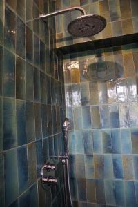 een douche in een badkamer met een betegelde muur bij Les jardins de Bandol, piscine et mer in Bandol