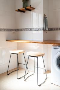eine Küche mit zwei Hockern und einer Waschmaschine in der Unterkunft Acogedor apartamento en Vallada in Vallada