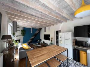 sala de estar con mesa de madera y cocina en Maison de charme proche gare, en Le Gond