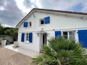 Una casa blanca con persianas azules. en Maison de charme proche gare, en Le Gond