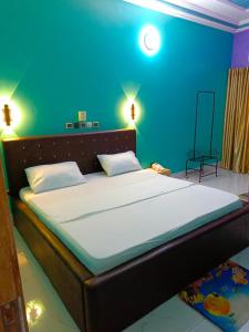 a bedroom with a large bed with a blue wall at HOTEL MAVILLA Cotonou in Cotonou