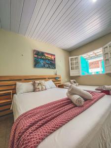 two beds in a bedroom with a roof at Pousada Verdes Mares Porto De Galinhas in Porto De Galinhas