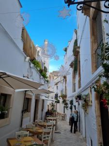 uma rua na cidade de Ravellollo com mesas e cadeiras em La Dimora nel Borgo em Locorotondo