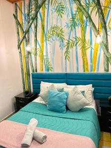 a bedroom with a bed with a blue head board at Hotel boutique stay la 10 in Medellín