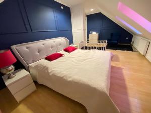 una camera da letto con un grande letto bianco con cuscini rossi di Premium Residence SPA & Garden a Glińcz